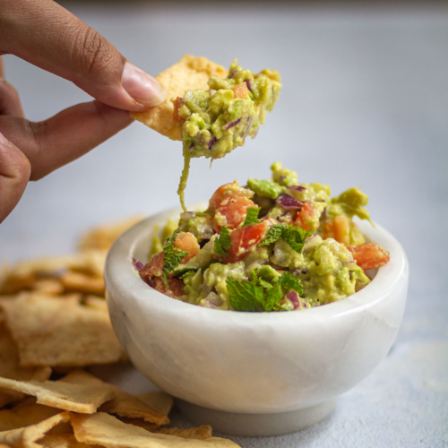 Taking a bite of avocado in crackers.