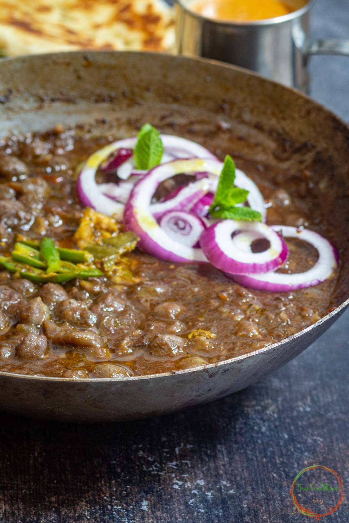 Authentic Punjabi chole curry with onions and mint garnish.