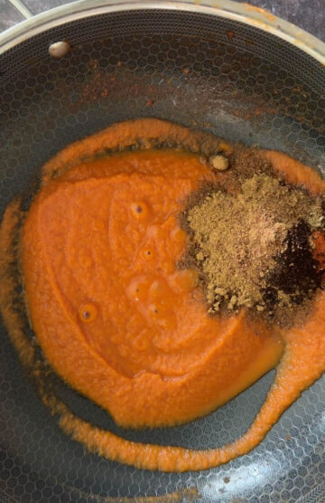 Add spices to blended onion & tomatoes.