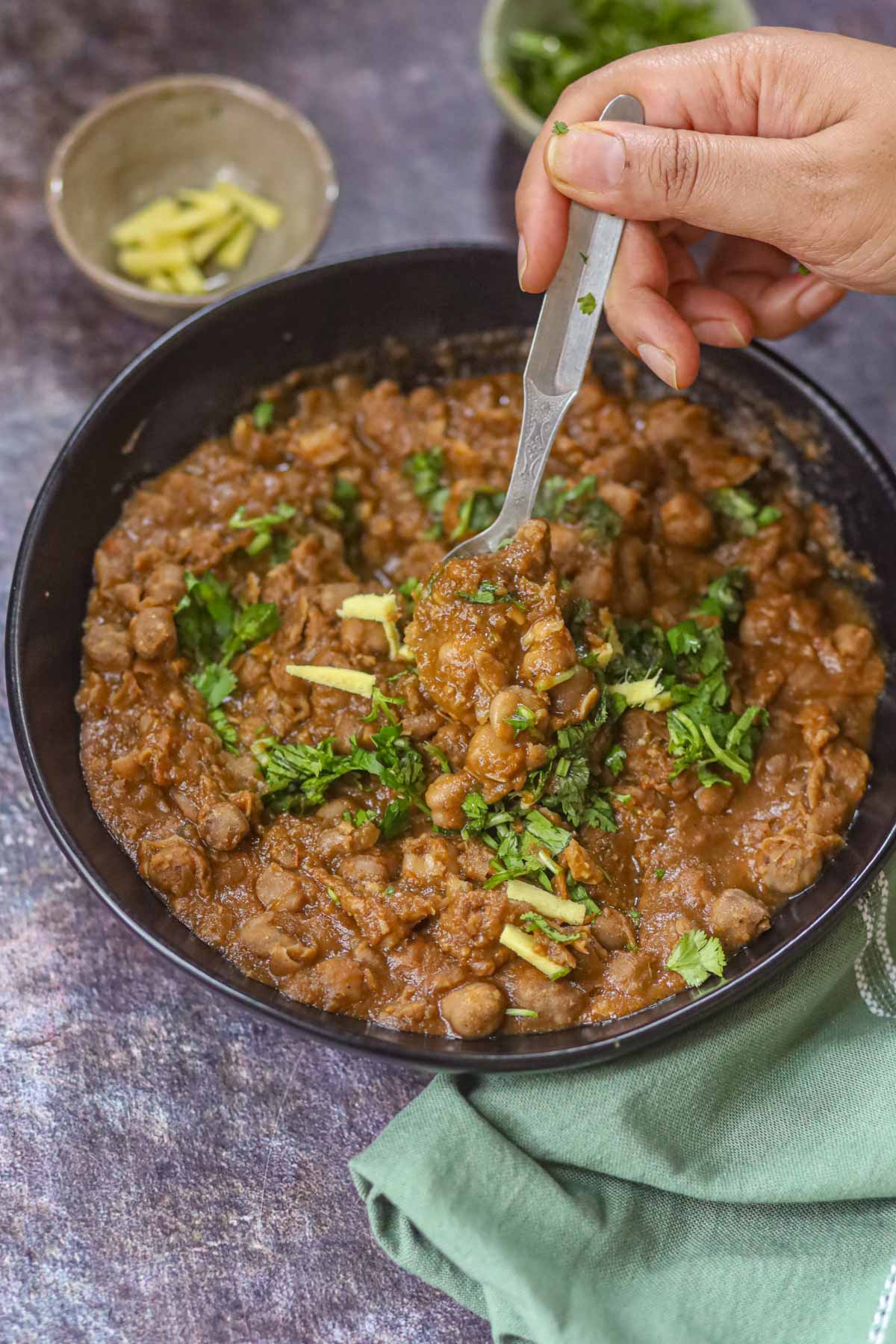 Spoonful of Delhi style chole showing thick chickpea curry texture.