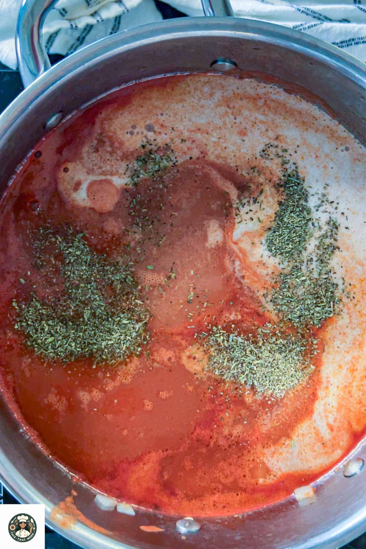 Image of large steel pot filled with coconut milk, Italian seasoning, vegetable stock, salt & pepper.