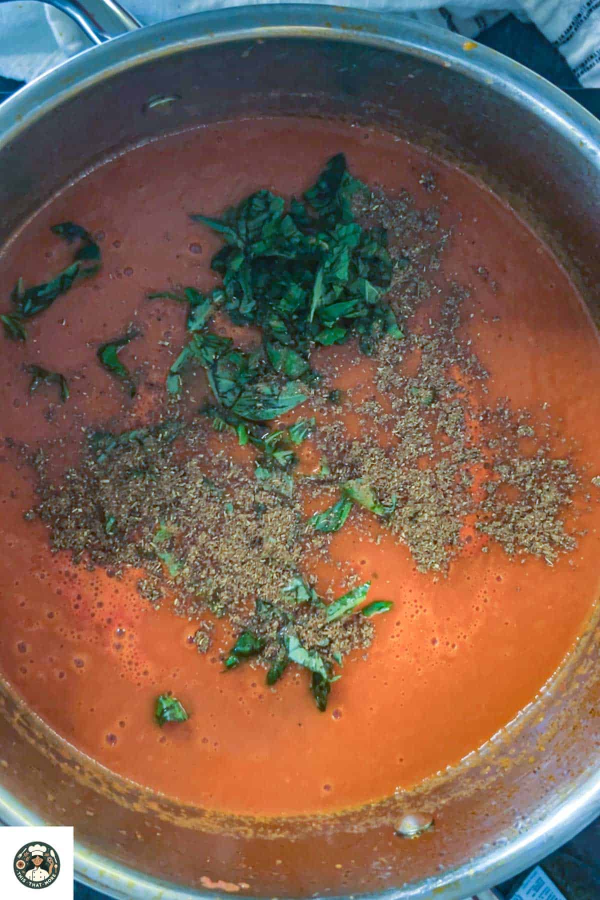 Image of large pot with basil leaves and garam masala (optional).