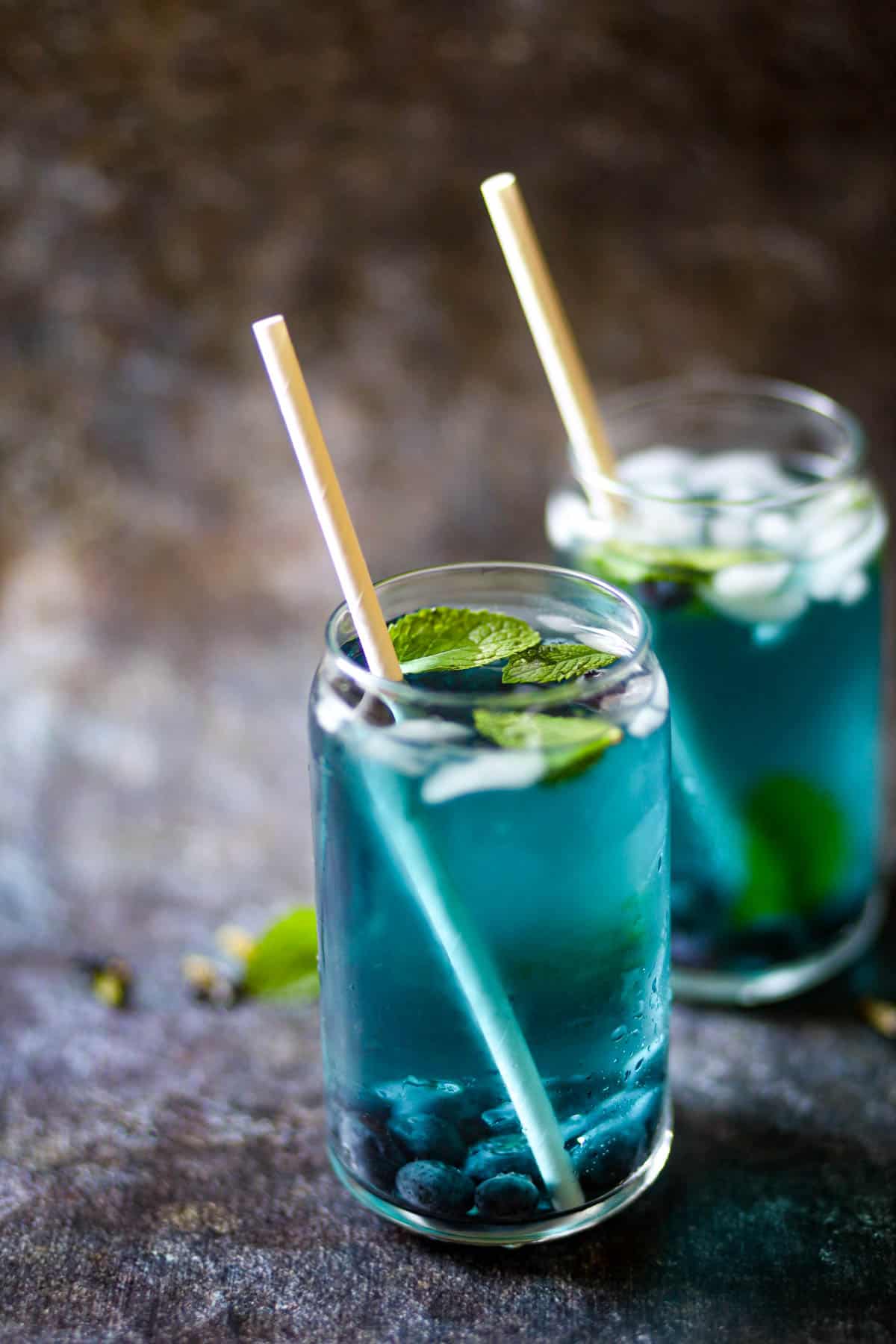 Blue Tea served with white straws.