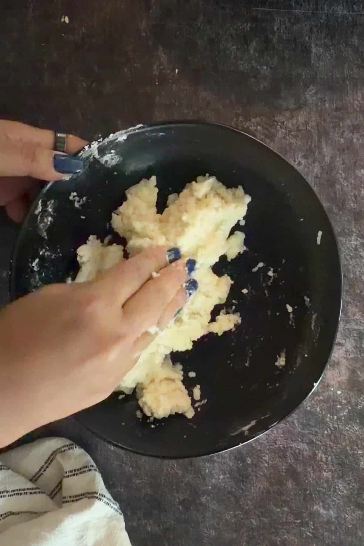 Mashed boiled potato being prepared for aloo tikki.