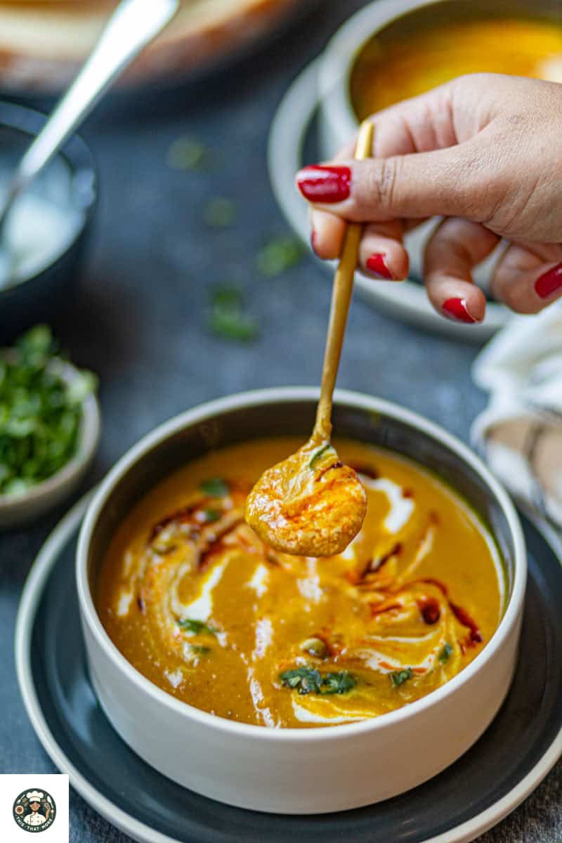 Image showing a spoonful of spiced carrot & lentil soup.