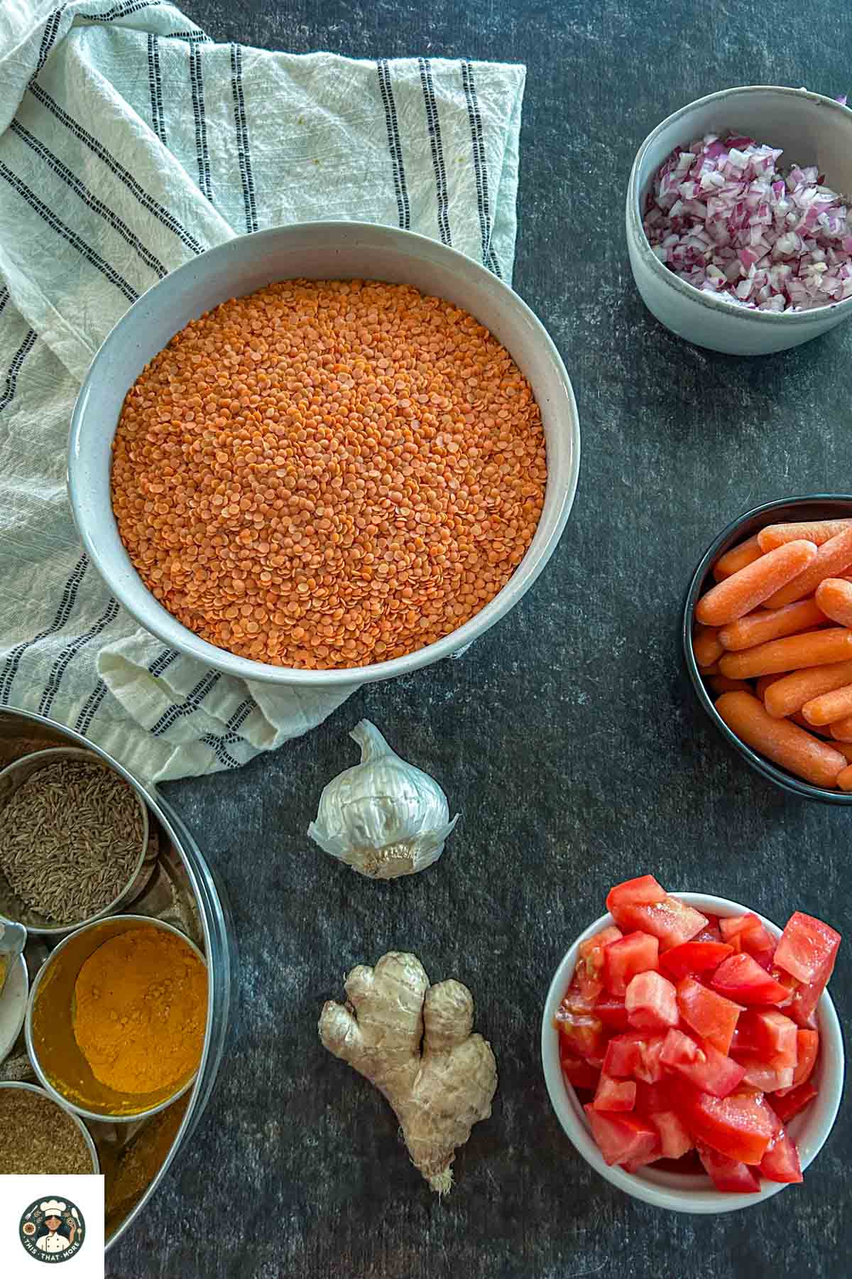Image showing all the ingredients including red lentils, carrots, tomatoes, onions, spices, and garlic.