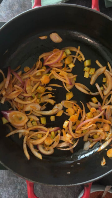 Sautéing onions, garlic, and green onions in chili oil.f