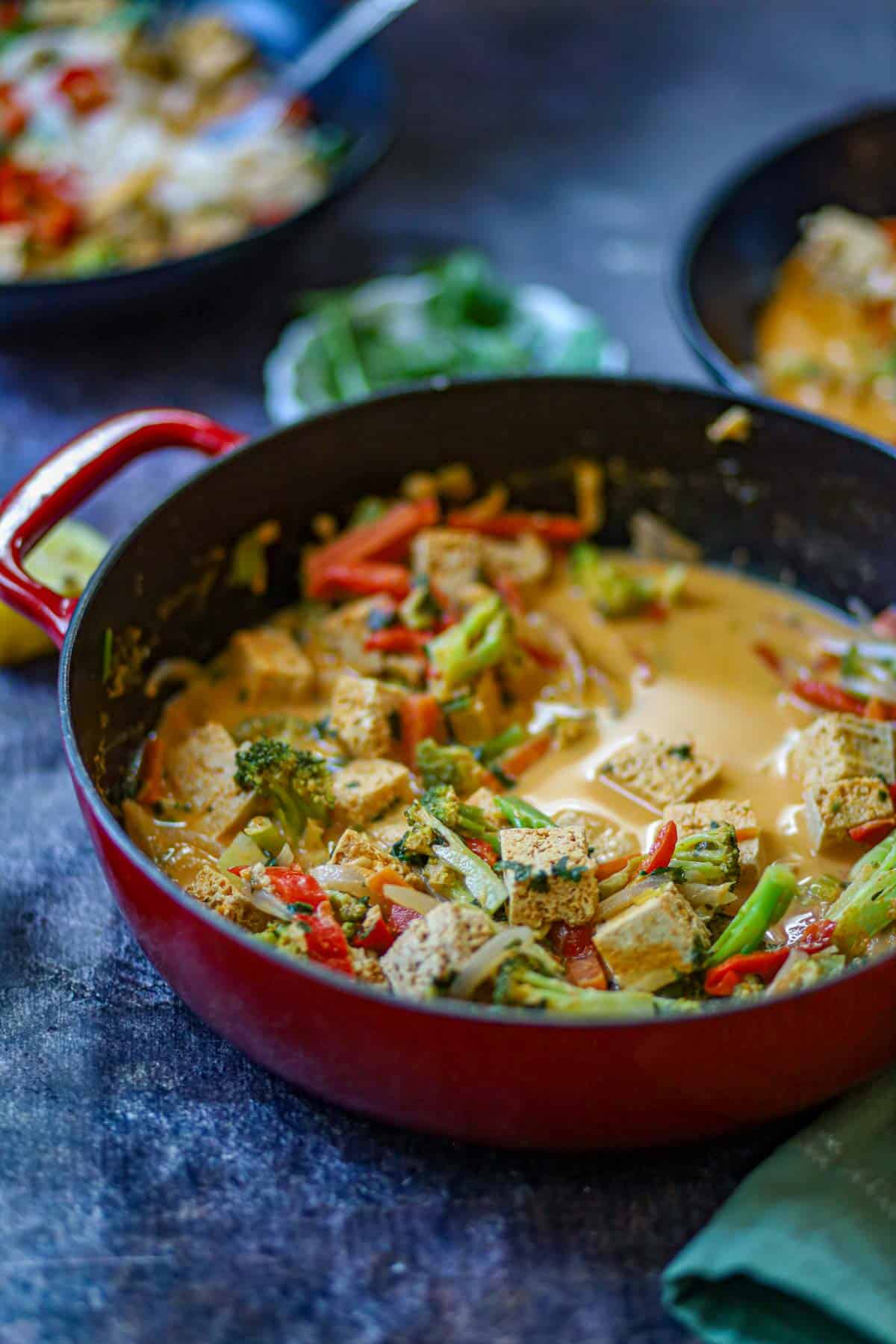 Bowl of Thai curry noodles with tofu, broccoli, peppers, rice noodles, and creamy coconut curry sauce.