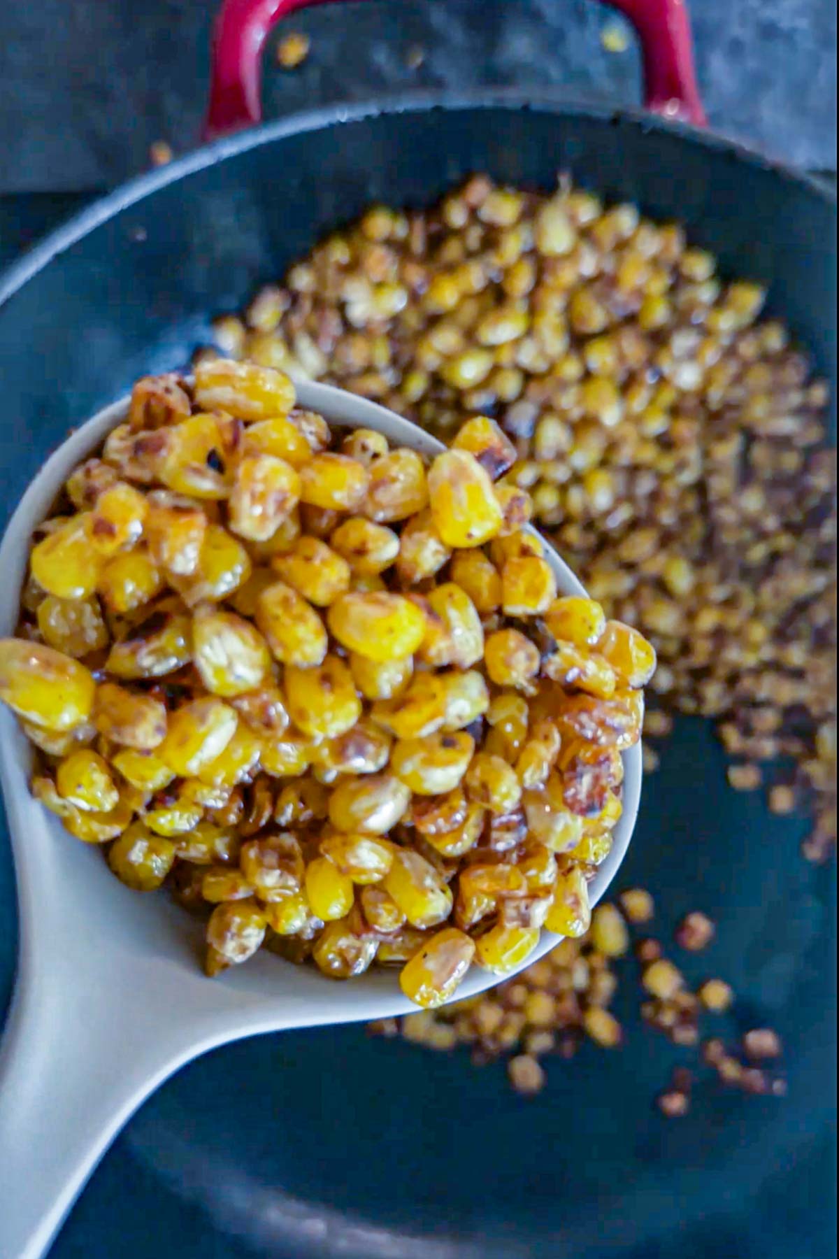 Boiled sweet corn draining in a fine-mesh strainer.
