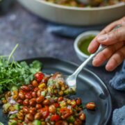 Street-style corn chaat being served with a spoon.