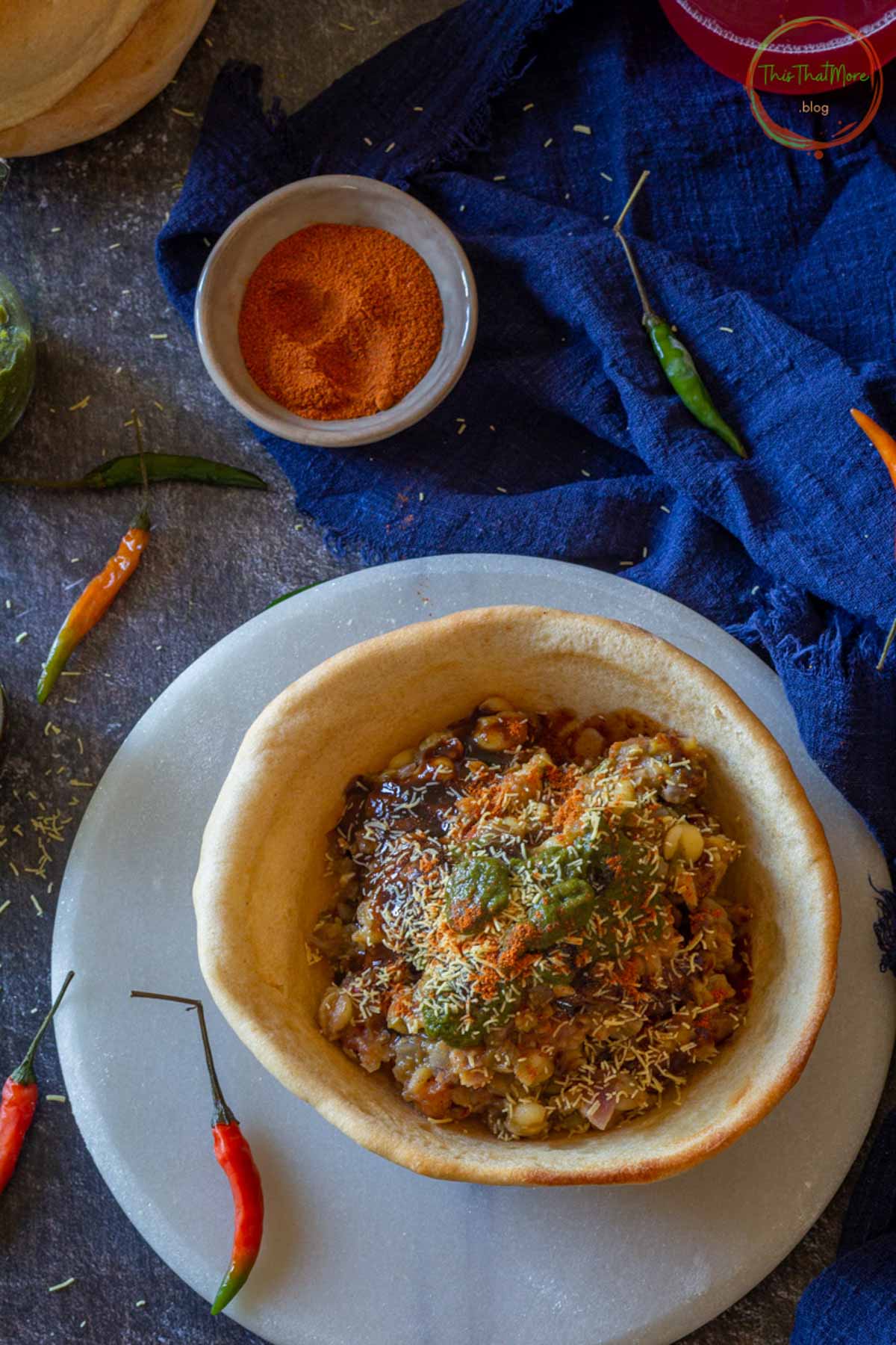 Naan bowl filled with chickpeas, paneer, chutney, and spices.