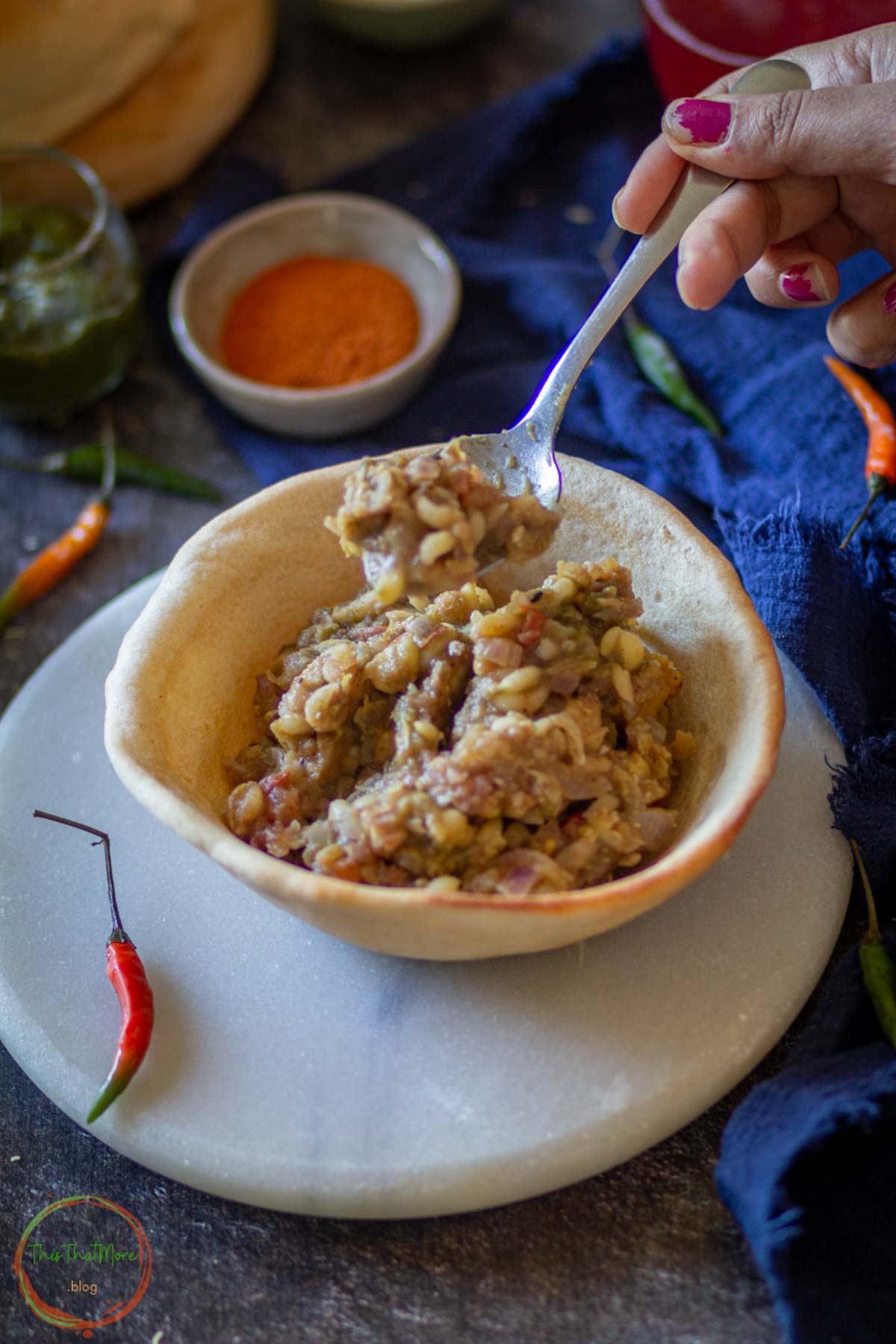 Spoon scooping chickpea filling from naan bowl.