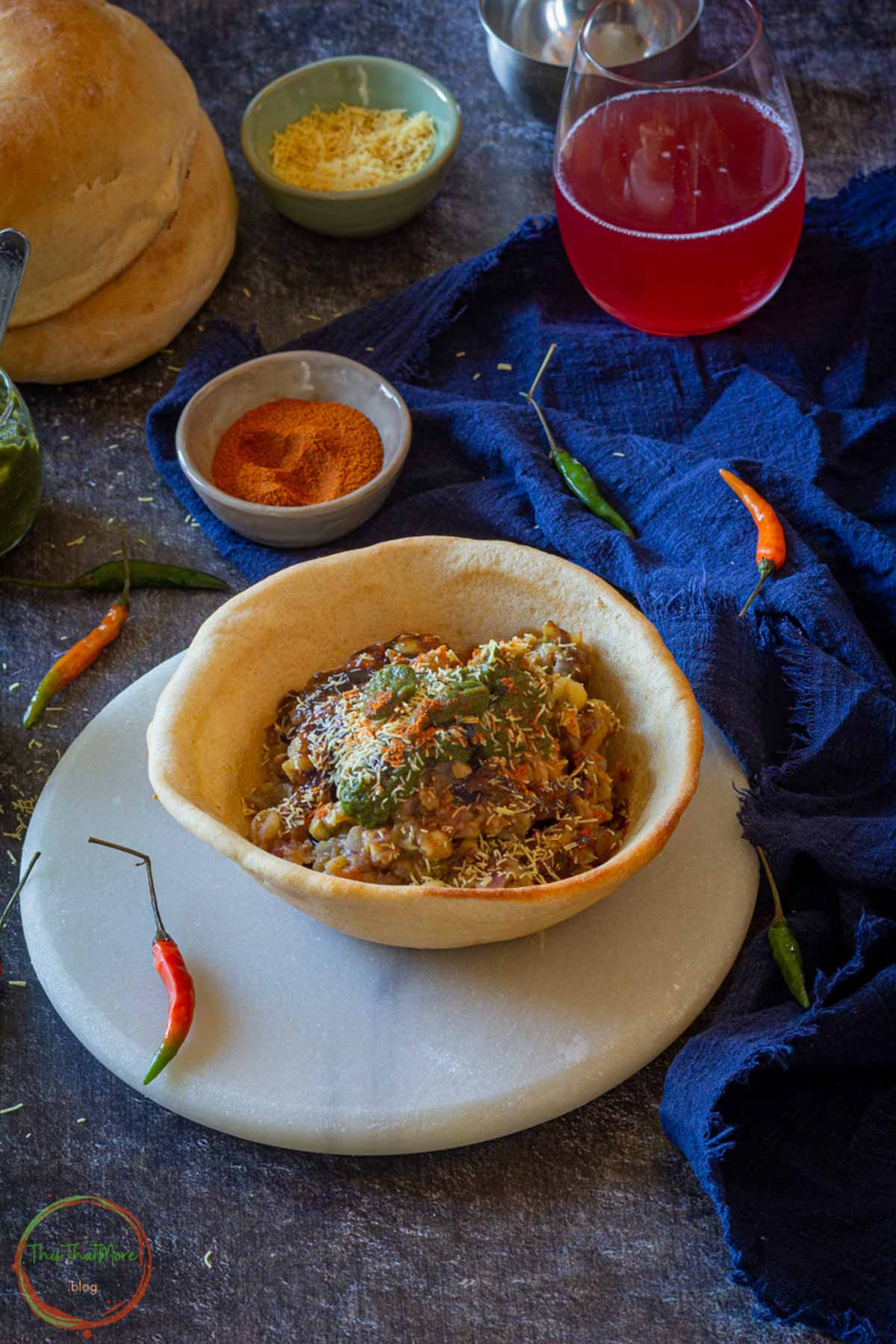 Naan bowl served with chickpea curry and chutney on plate.