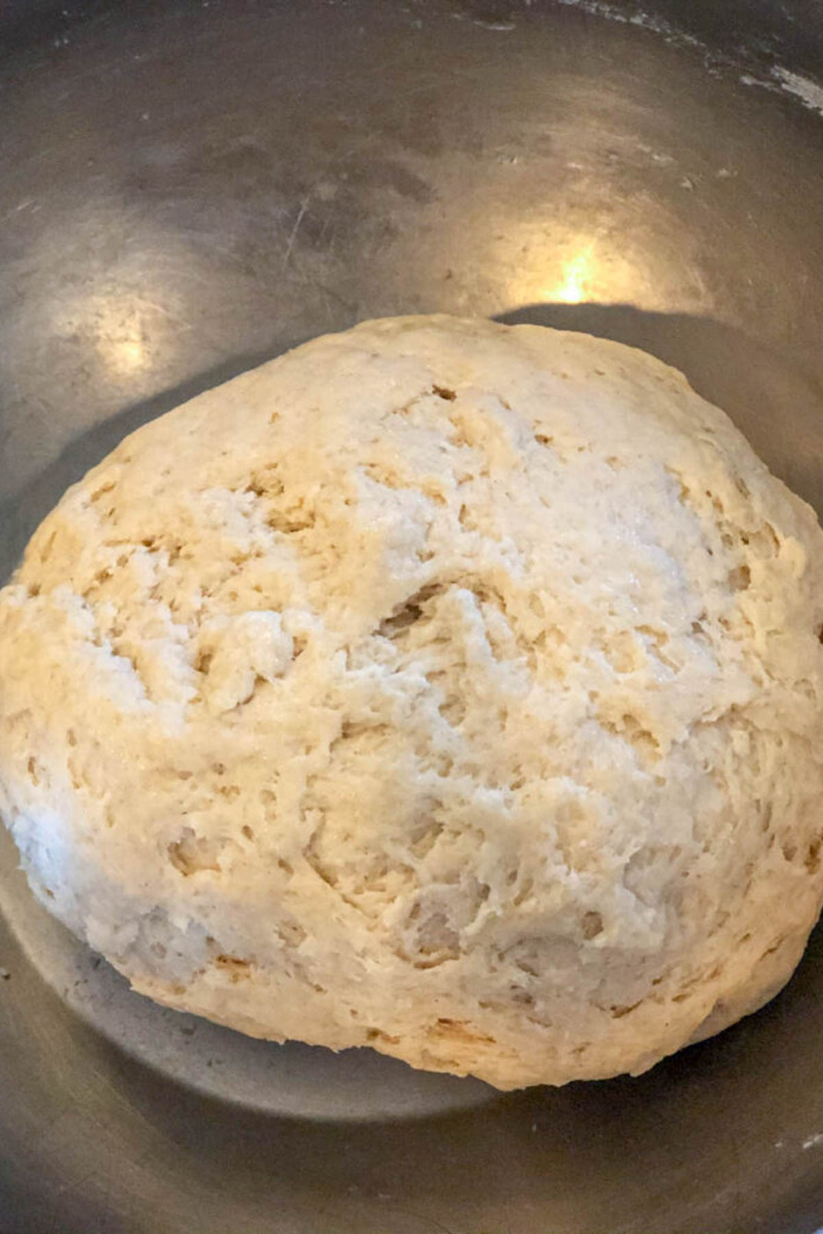 Naan dough resting in bowl before shaping.