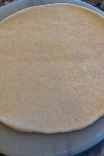 Naan dough rolled flat before shaping into bowl.