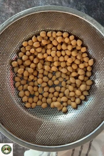 Cooked chickpeas drained and rinsed in a strainer for hummus.