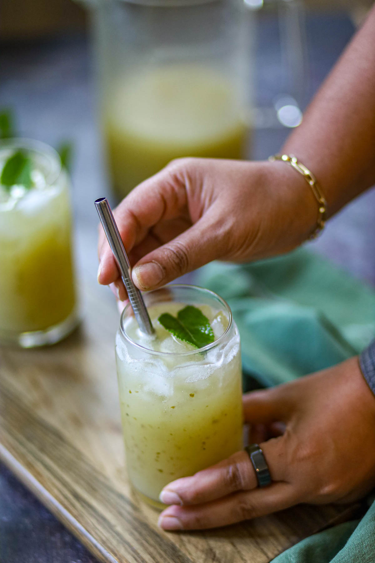 Glass of aam panna with mint and metal straw.