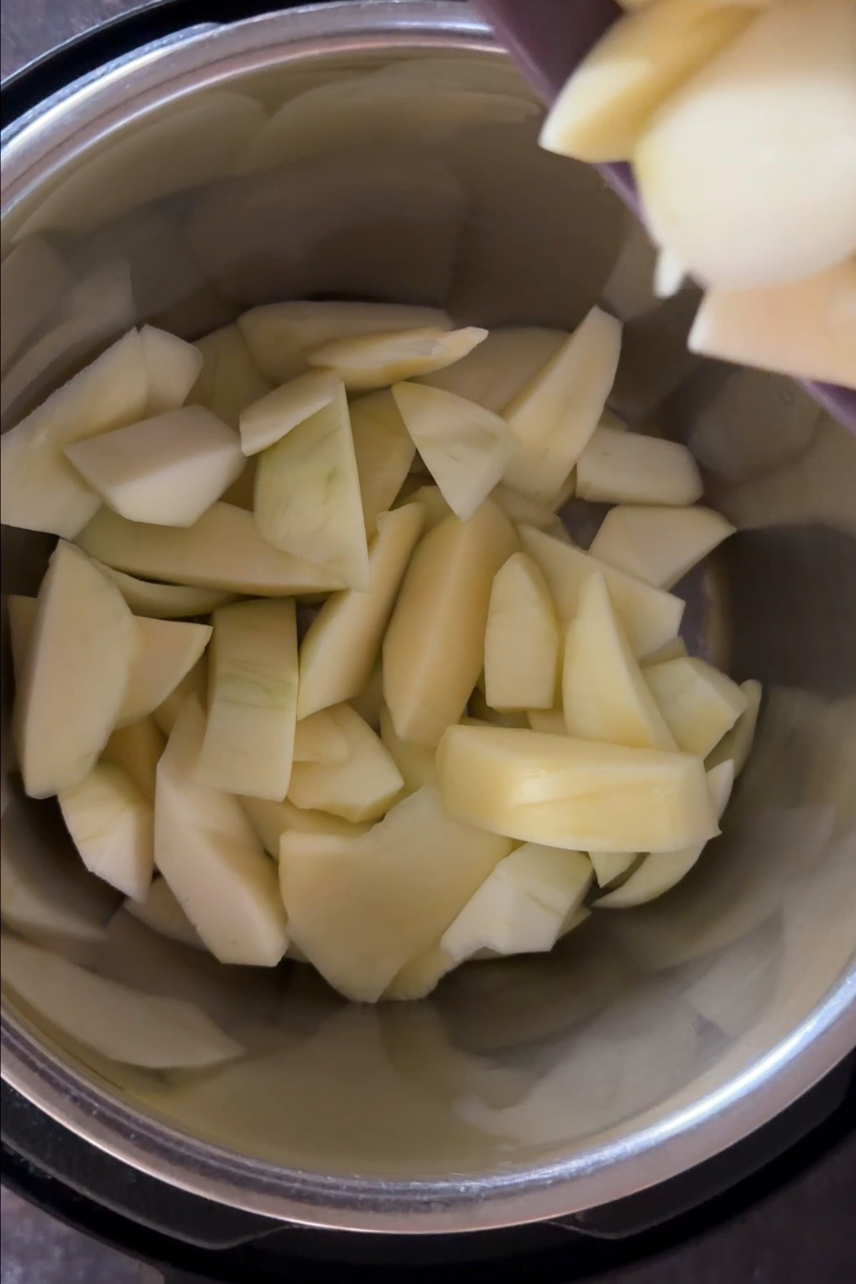Peeled raw green mango pieces added to the pot for aam panna.