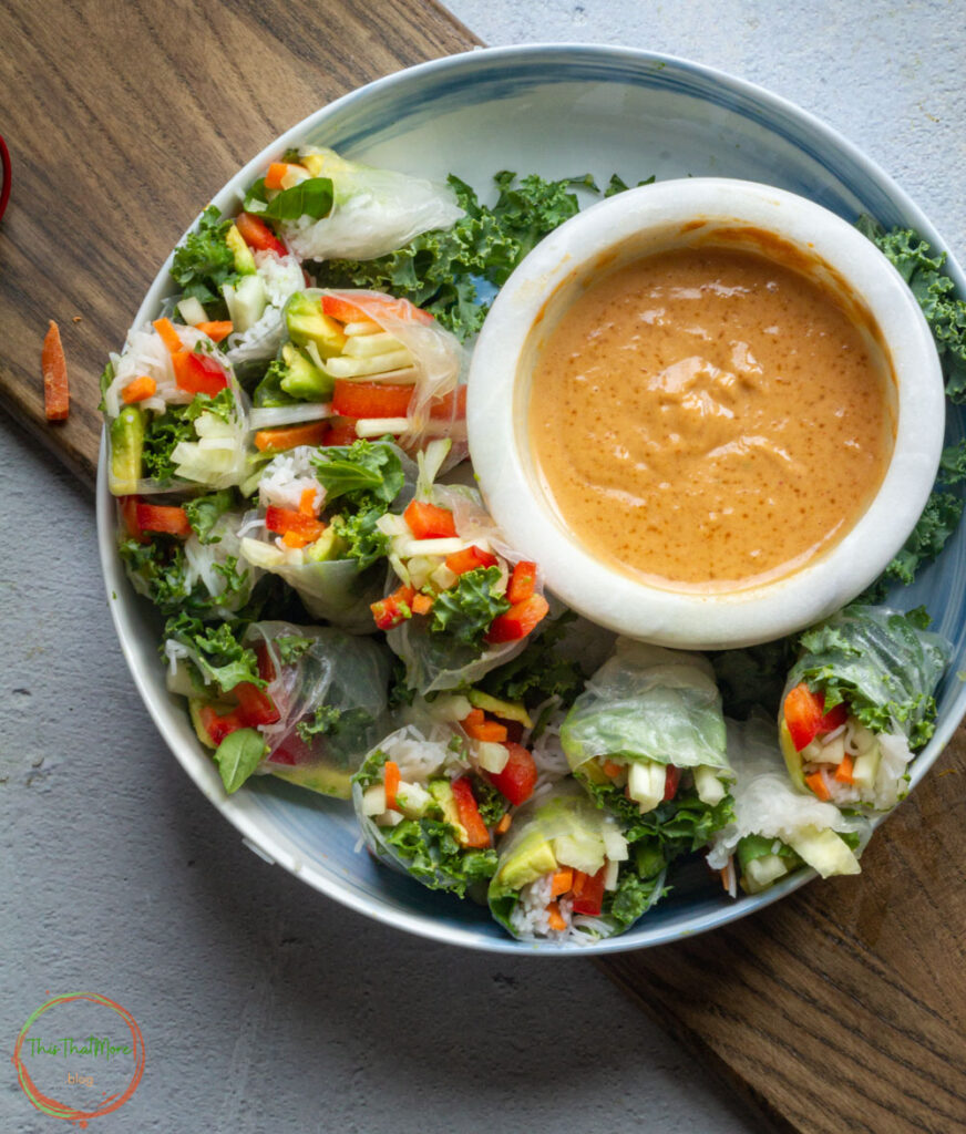 Served Vegan Summer Rolls in a white plate with peanut sauce.