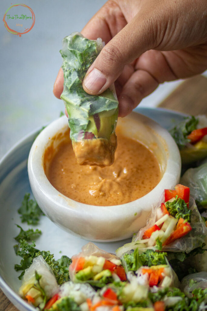 Dipping Vgean SImmer Rolls in Spicy Peanut Sauce.