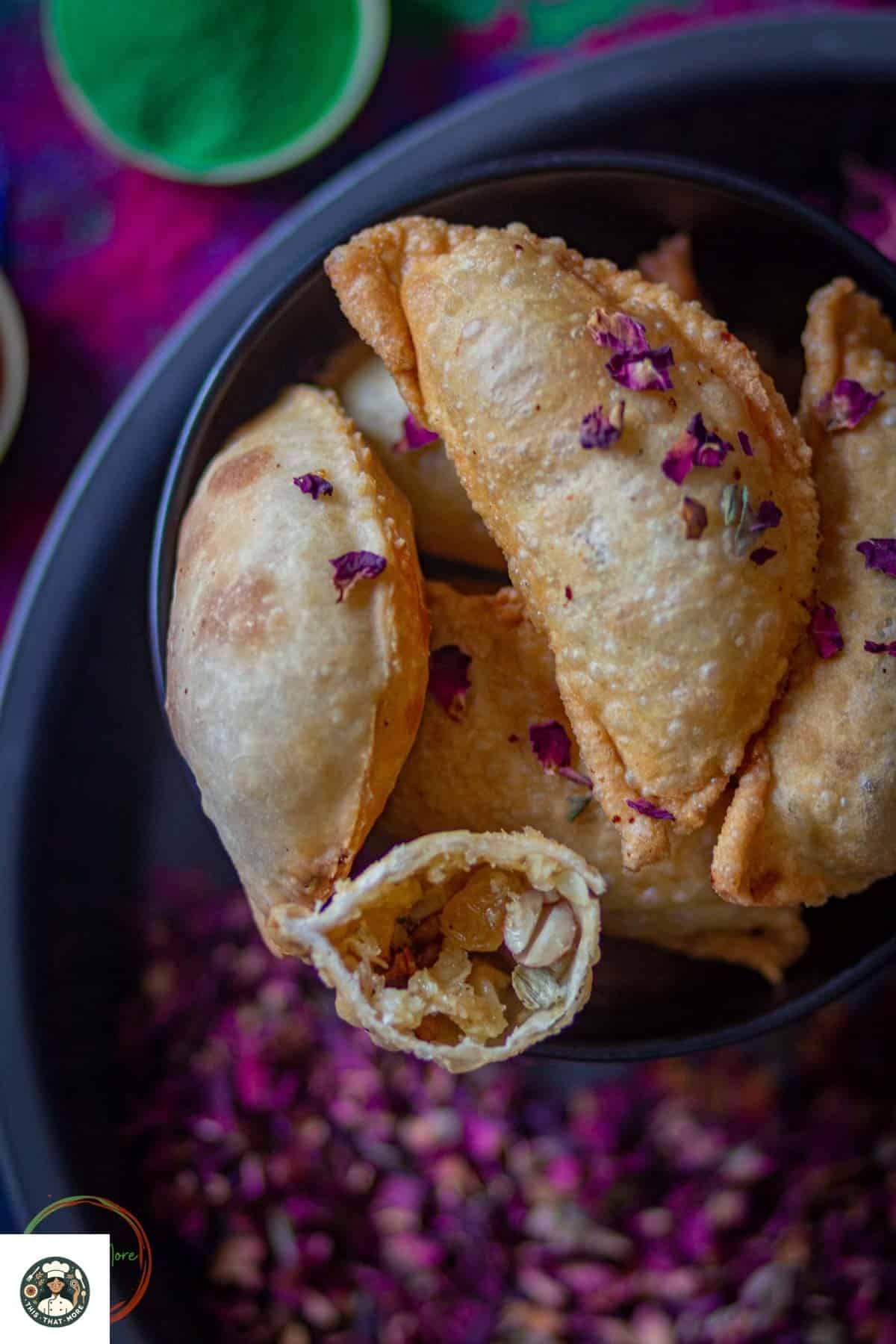 Image of Gujiya Recipe with coconut filling served in a black bowl for holi.