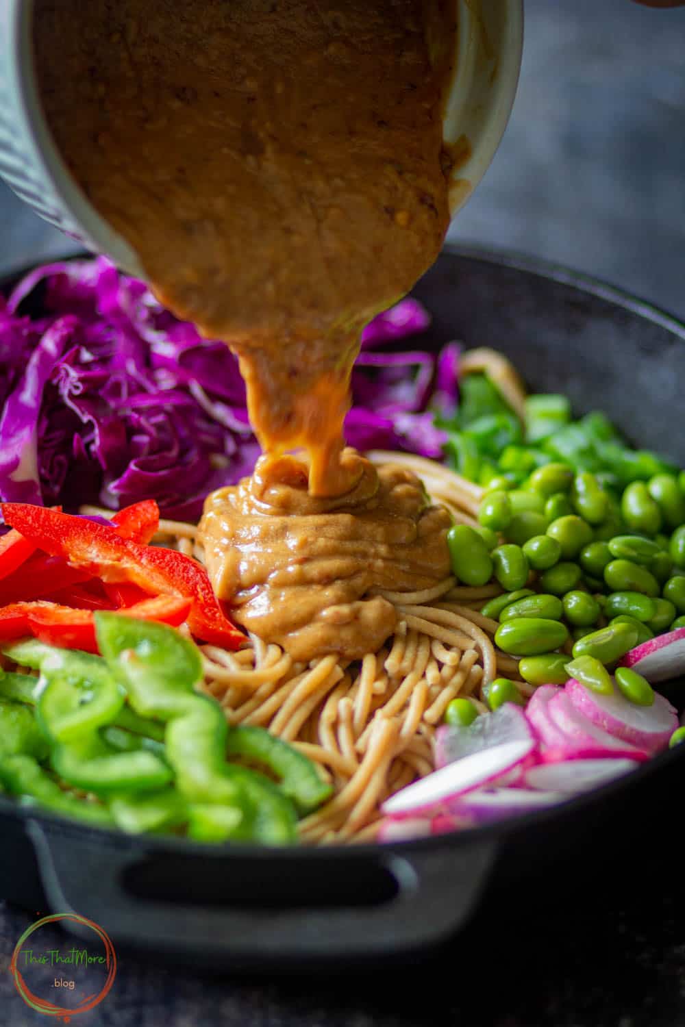 Pouring Peanut Sauce over noodles and veggies.
