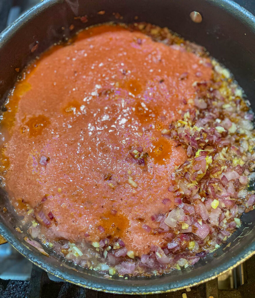 add tomato puree and cook