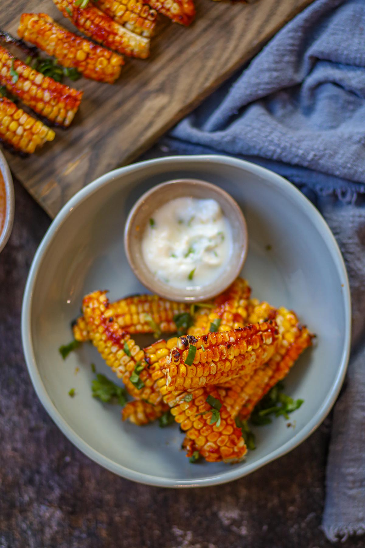 Gochujang corn ribs in a serving bowl with yogurt dip.