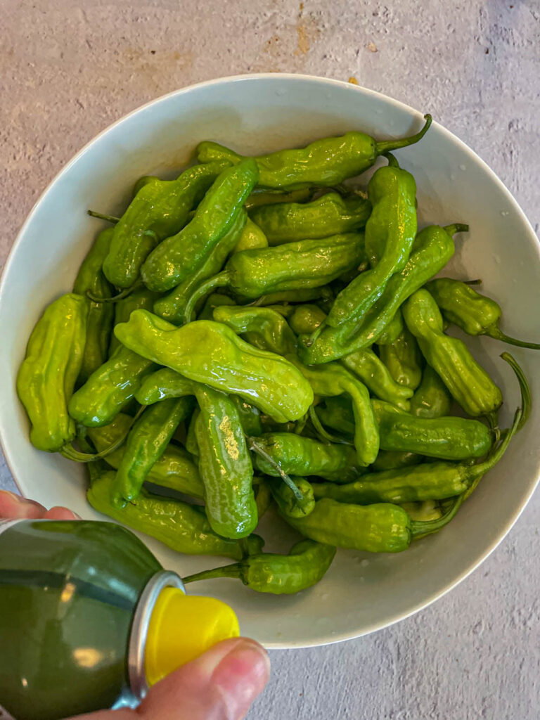 spray oil on the shishito peppers