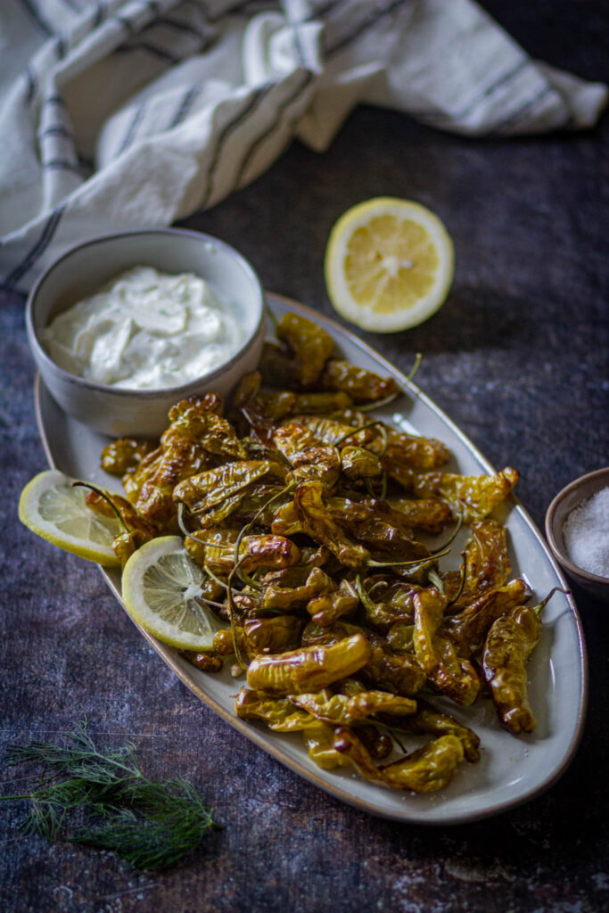 shishito peppers on a white platter served with yogurt ranch