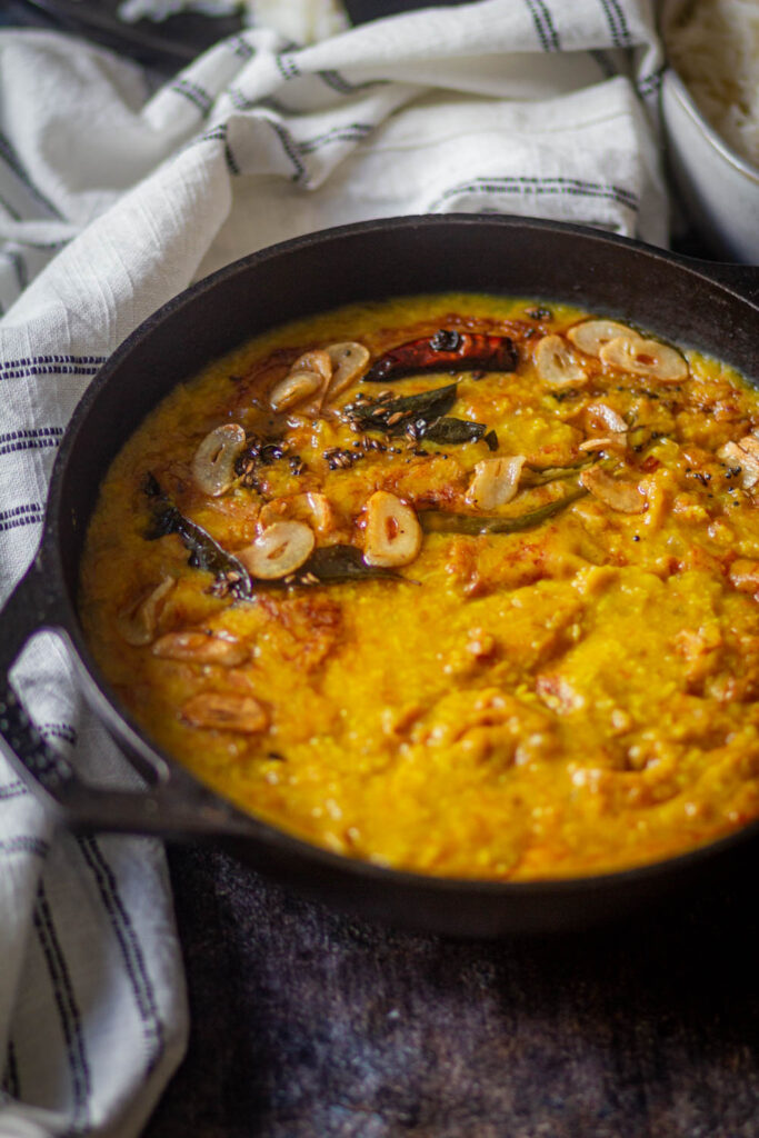 Moong dal in a black kadai with tempering of garlic & cumin seeds.