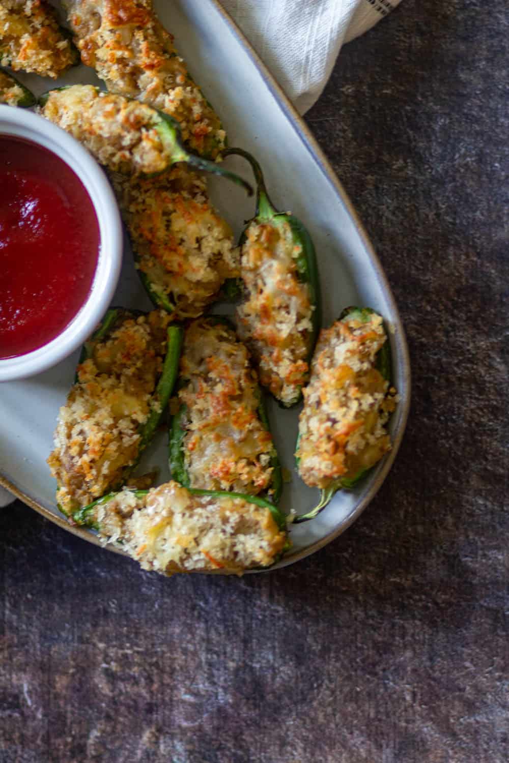 air fryer jalapeno poppers on a white plate & served with sauce