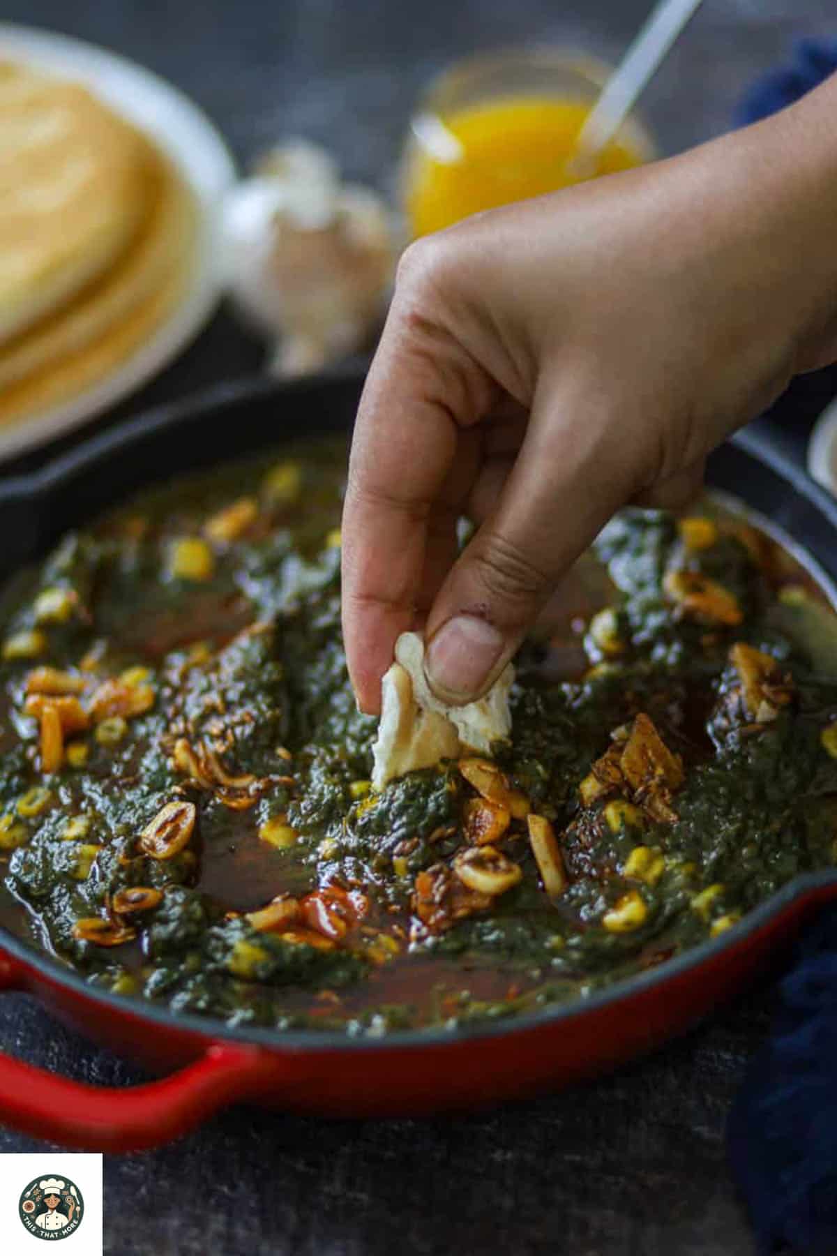 Image of a bite of naan dipped in the recipe of palak corn.