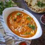 Image of shahi paneer served in a white bowl and garnished with cilantro and cream.