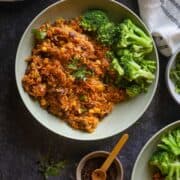 Image of Mexican Rice served in a green bowl with steamed broccoli.