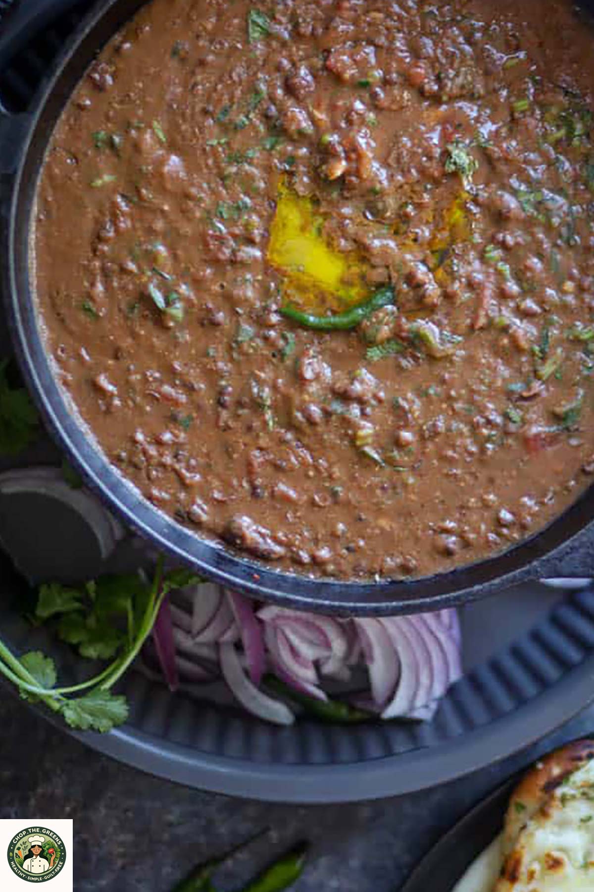 Creamy instant pot dal makhani served in a cast iron pan with butter and green chili.