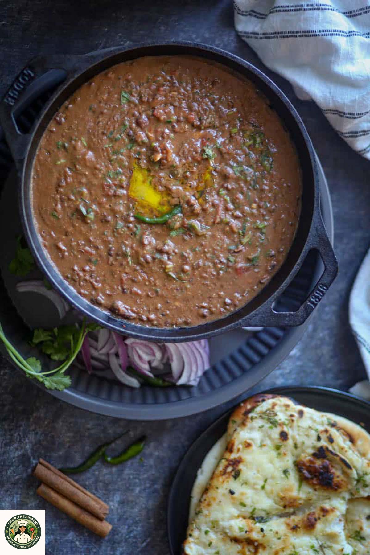 Creamy Instant Pot Dal Makhani served in a black pan with butter on top.