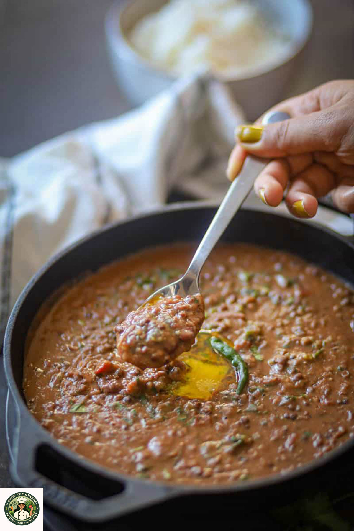 Spoon lifting creamy Instant Pot Dal Makhani with butter.