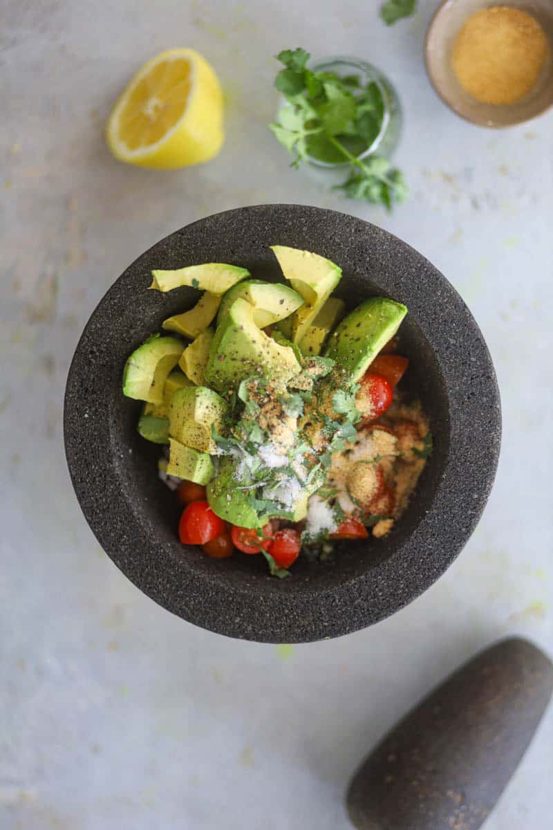 add veggies, avocado, seasoning in mortar pestle.