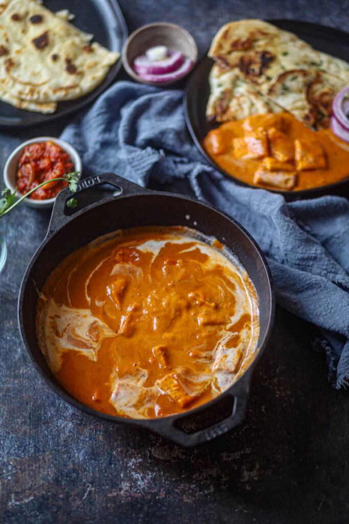Butter Paneer served in a black wok.