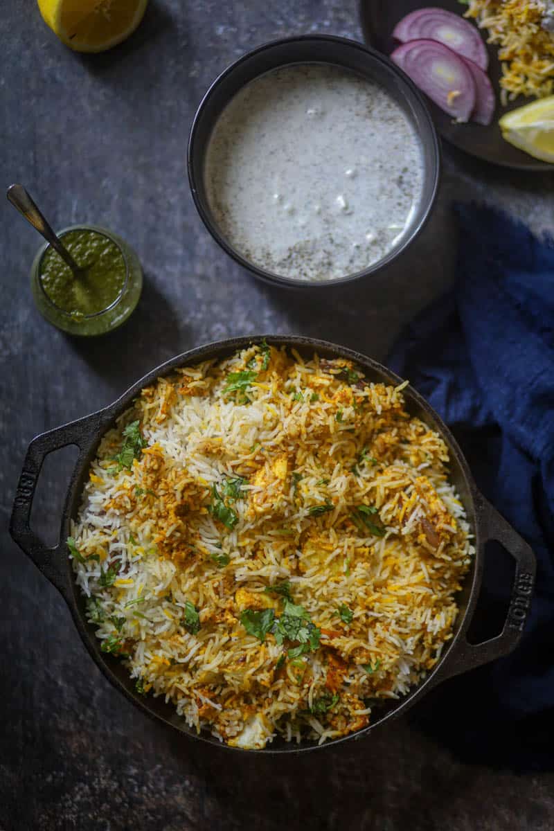 Paneer Biryani served with raita or yogurt.