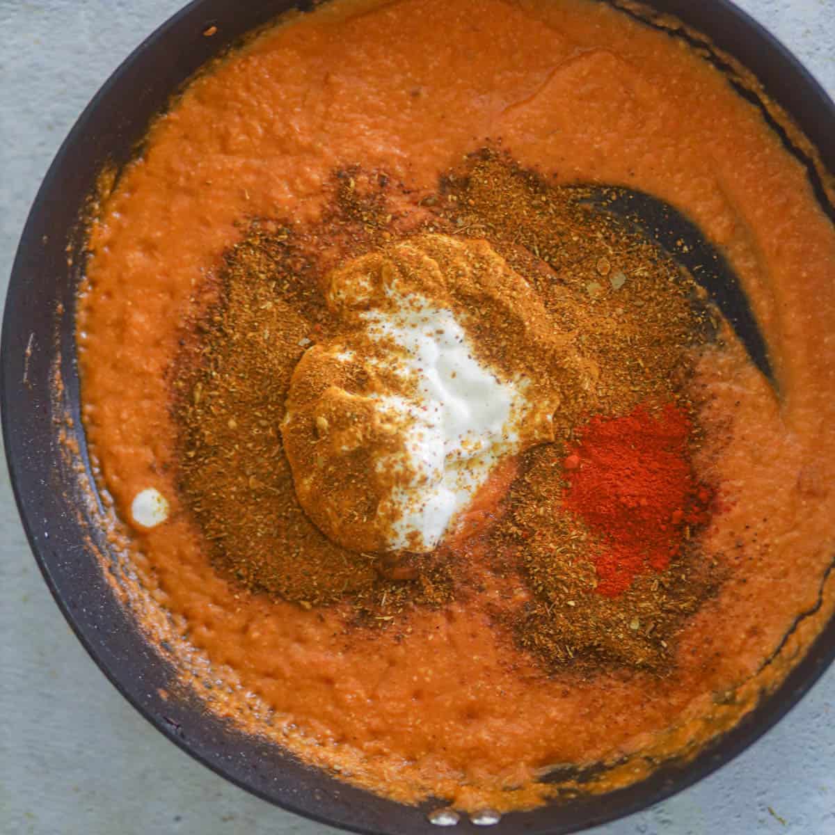 Add yogurt, biryani masala, and Kashmiri red chili powder.