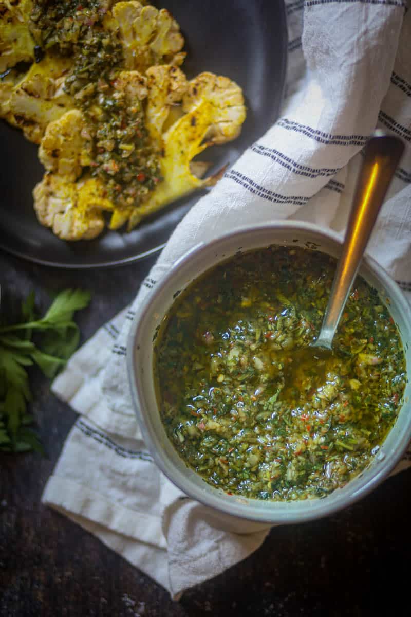 Cilantro Chimihcurri Sauce served in a white bowl with spoon. 