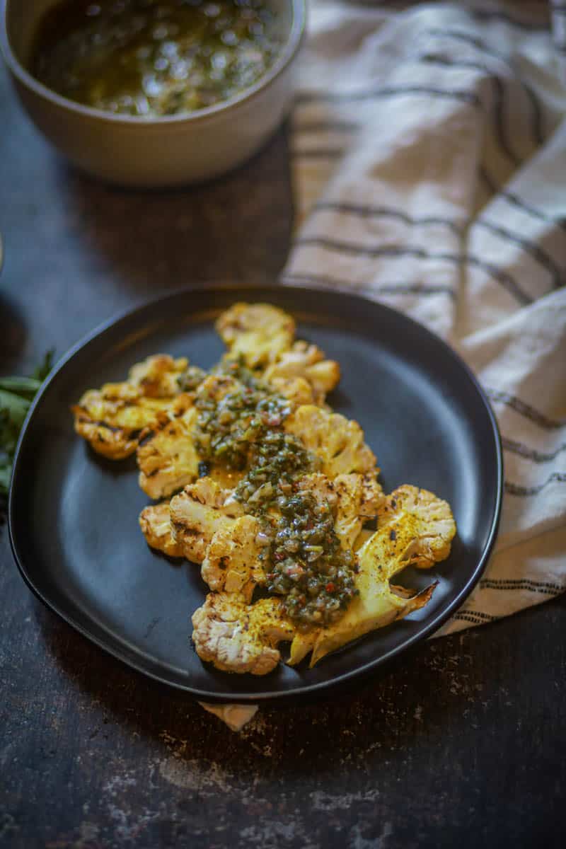Cauliflower steaks served with cilantro chimichurri sauce.