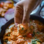 Taking abite of paneer tikka masala gravy with naan.