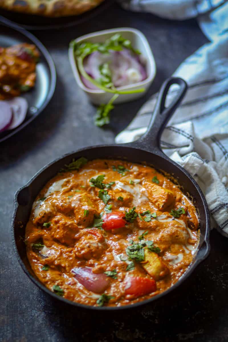 Paneer tikka Masala served in a black pan.
