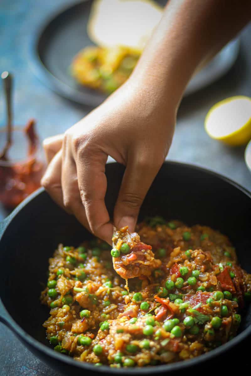 Taking a bite of baingan bharta with roti.