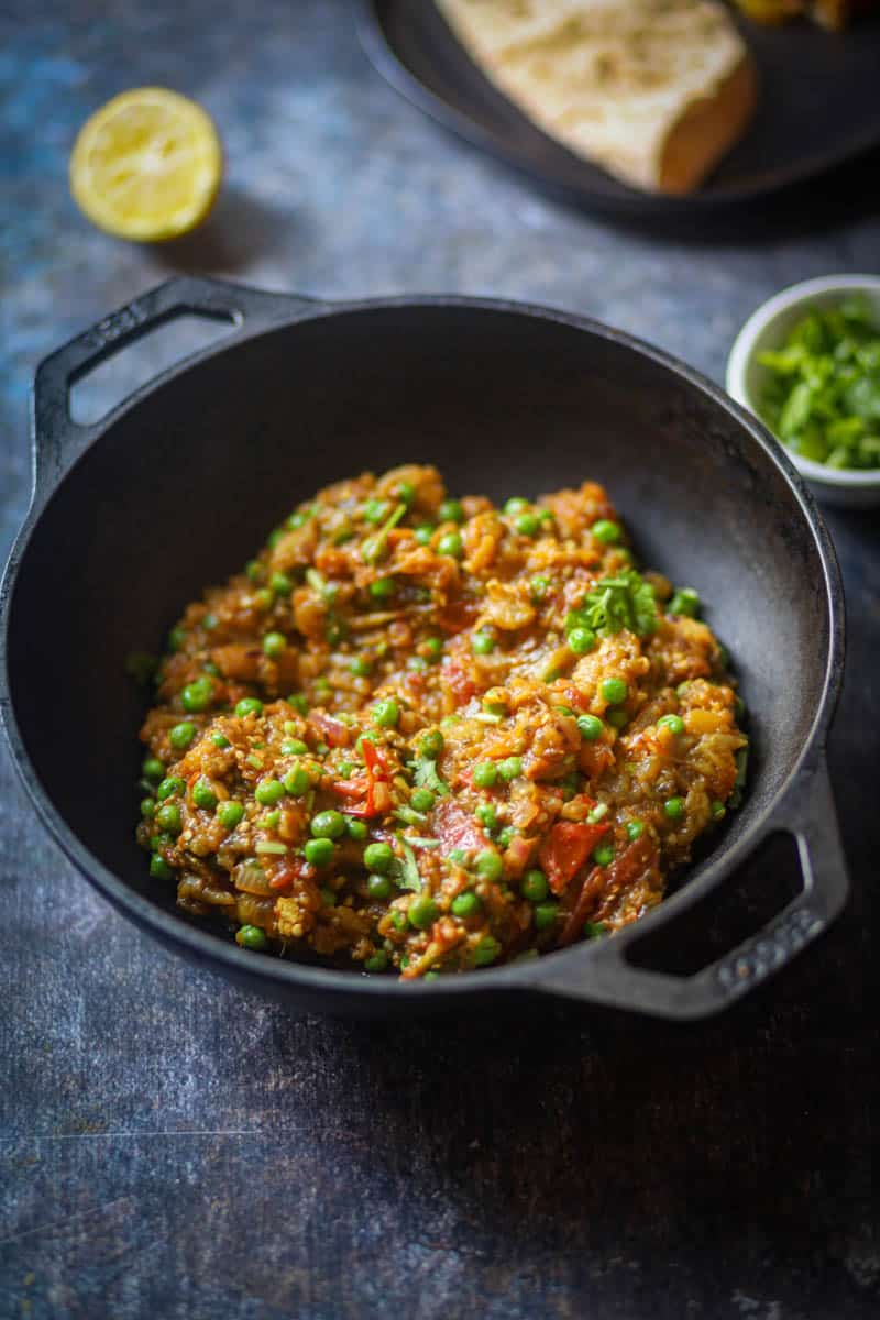 Baingan Bharta served in cast iron with cilantro.