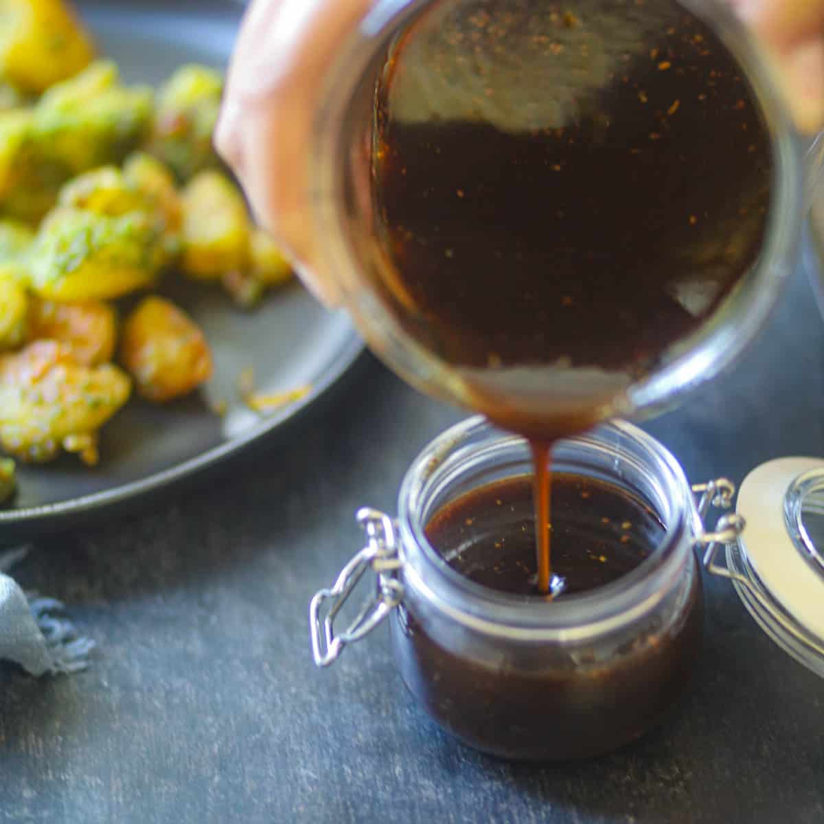 Pourinf imli chutney in a mason jar.