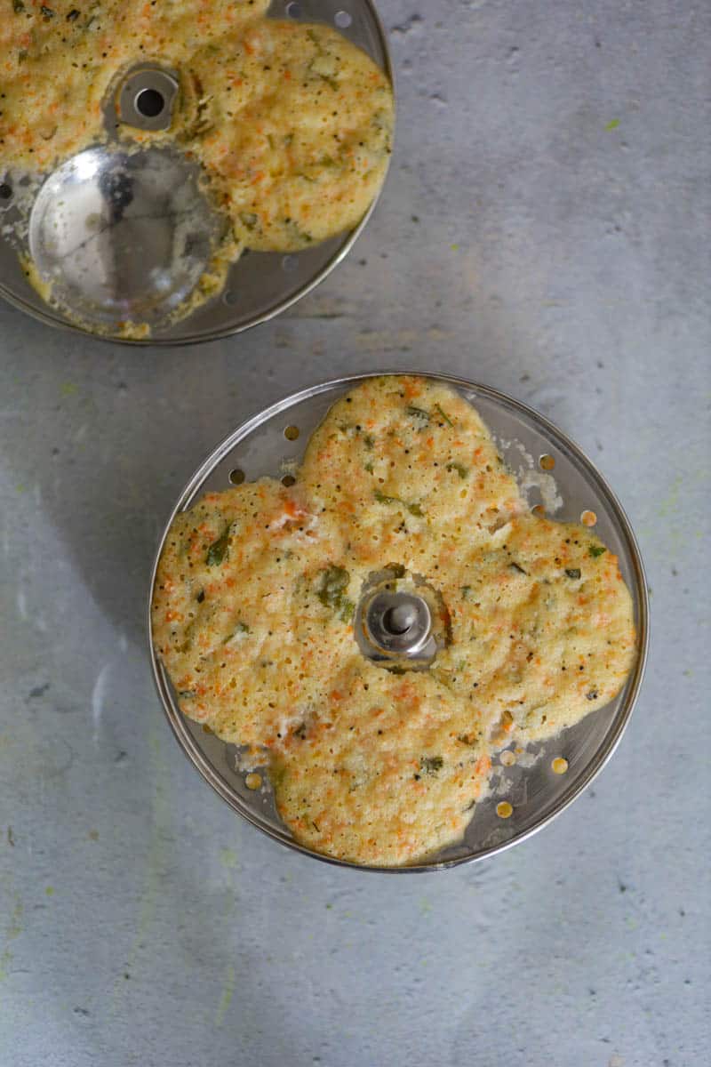 Fill the idli molds with batter and steam them.